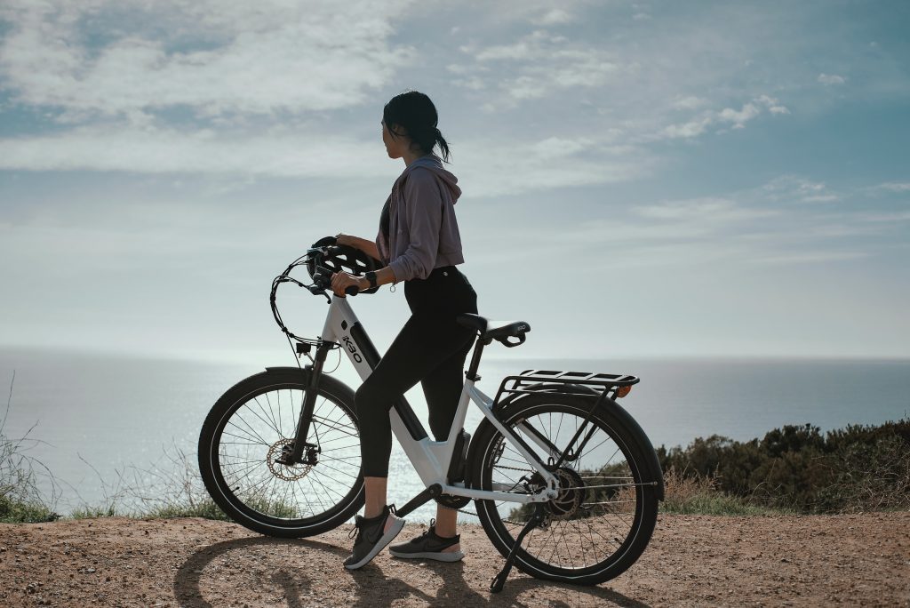 woman on electric bike watching seaside from a mountain