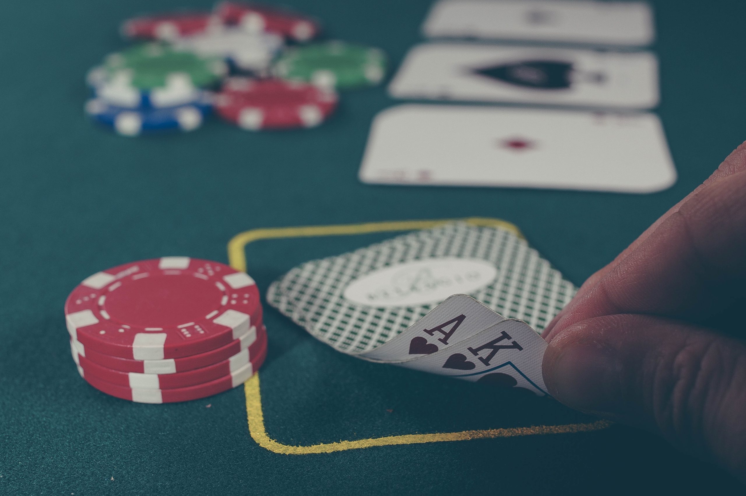 Poker table man unfolding two cards